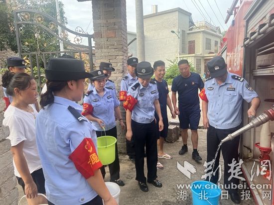 民輔警跟隨消防水車作業(yè)，通過肩挑手提的方式將清水送入行動不便的老年、殘障村民的家中（通訊員 李麗君 攝） (3).jpg.jpg
